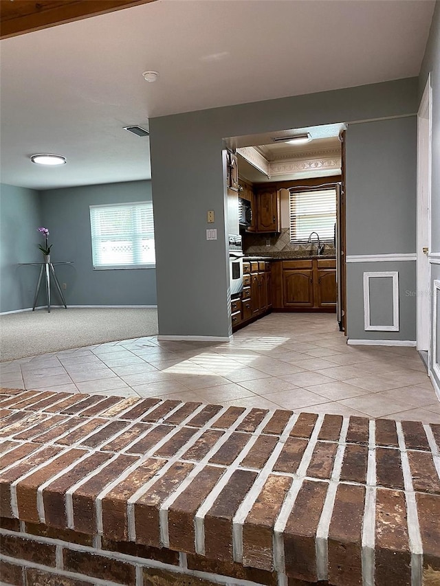 kitchen featuring stainless steel oven, light tile patterned floors, sink, and tasteful backsplash