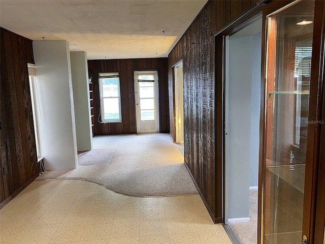 corridor with light colored carpet and wooden walls