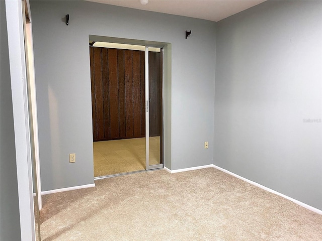 unfurnished bedroom featuring light carpet and a closet