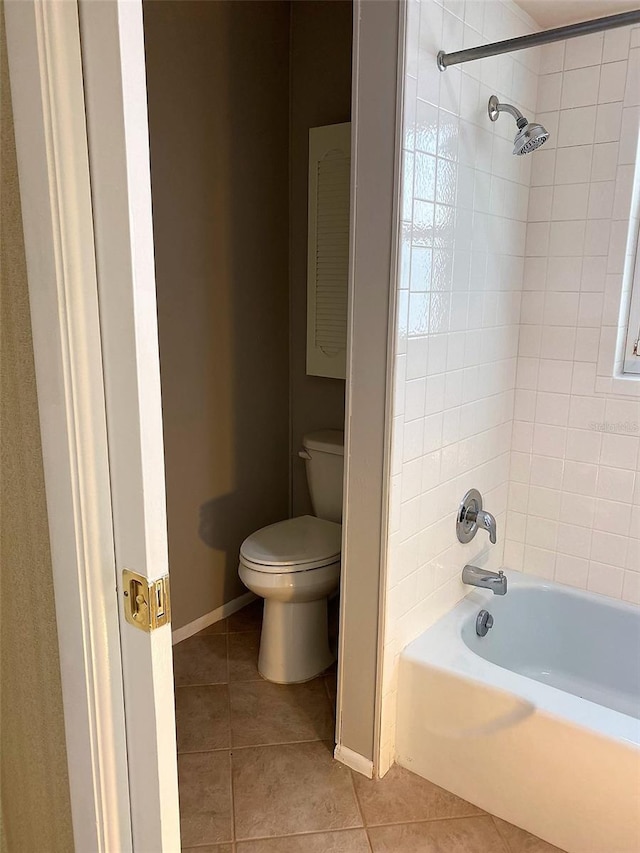 bathroom featuring toilet, tiled shower / bath combo, and tile patterned flooring