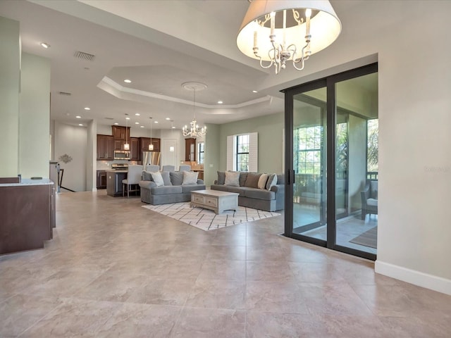 living room featuring a chandelier and a raised ceiling