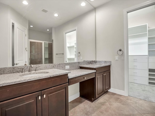 bathroom featuring tile patterned flooring, vanity, and walk in shower