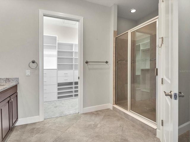 bathroom featuring vanity, tile patterned floors, and a shower with shower door