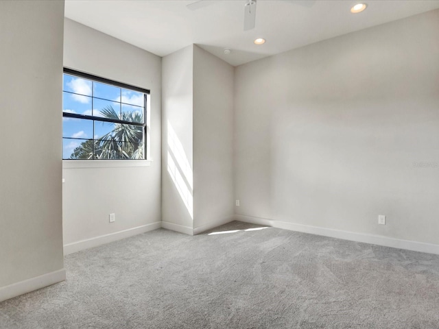 spare room with ceiling fan and light colored carpet