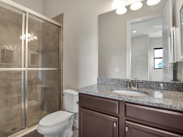 bathroom featuring vanity, an enclosed shower, and toilet