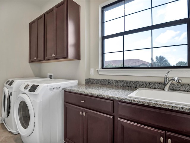 laundry room with a wealth of natural light, washer and dryer, and cabinets