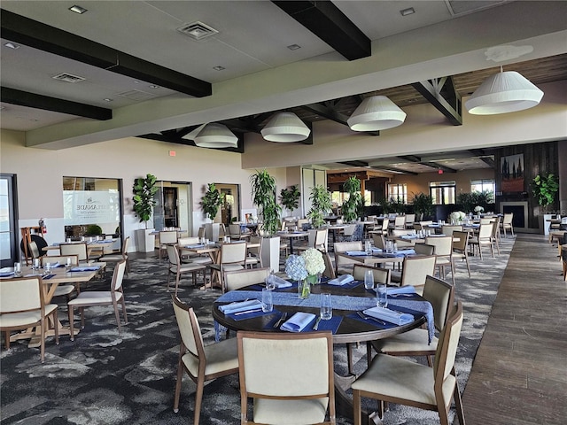 dining space featuring beamed ceiling and dark hardwood / wood-style flooring