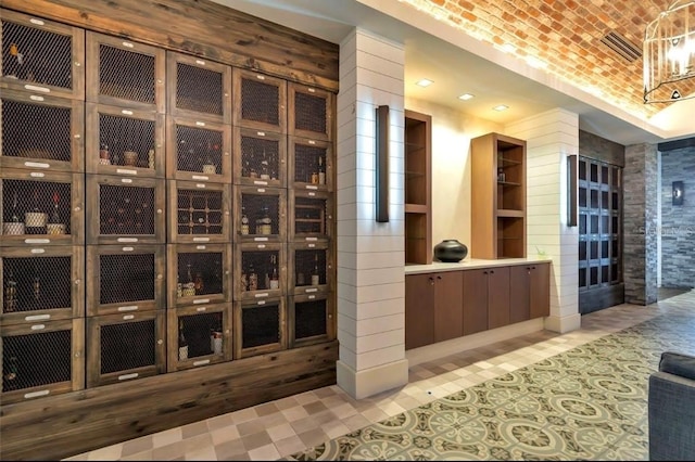 wine room featuring a notable chandelier and brick ceiling