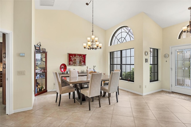 tiled dining space featuring high vaulted ceiling and an inviting chandelier