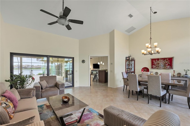 tiled living room featuring high vaulted ceiling and ceiling fan with notable chandelier