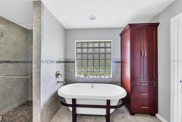 bathroom with tile walls and shower with separate bathtub