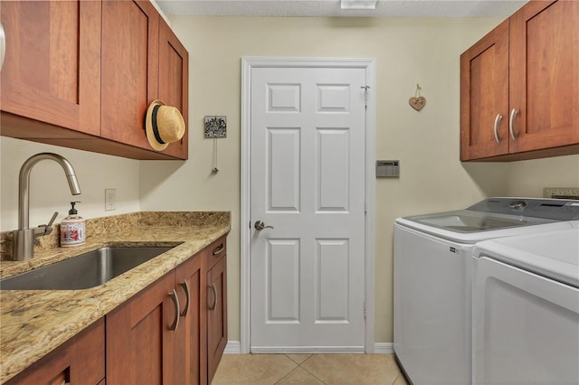 laundry area with cabinets, sink, a textured ceiling, light tile patterned floors, and washer and dryer