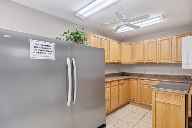 kitchen with light brown cabinetry, ceiling fan, stainless steel refrigerator, and light tile patterned floors