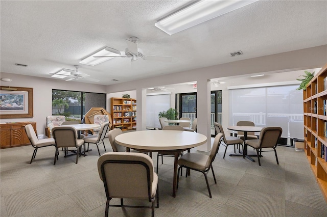 dining room with a textured ceiling and ceiling fan