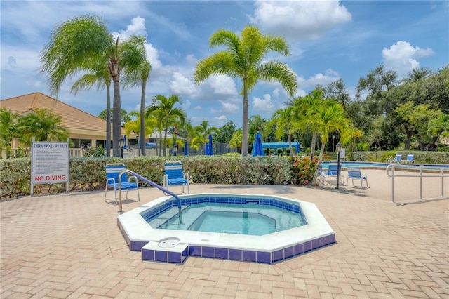 view of swimming pool with a hot tub