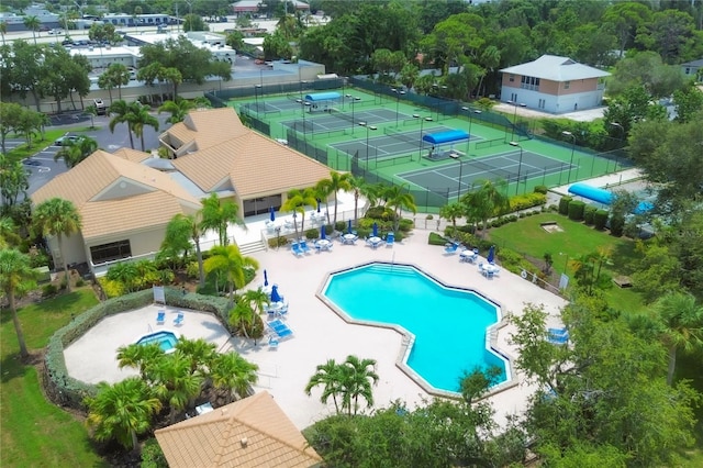 view of swimming pool with tennis court and a patio area