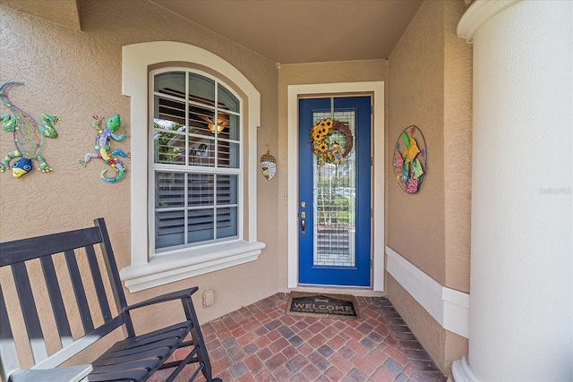 view of exterior entry featuring covered porch