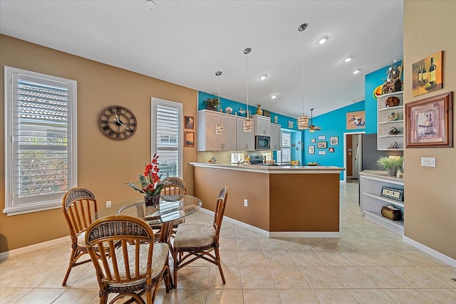 kitchen featuring kitchen peninsula, decorative light fixtures, light tile patterned floors, and a textured ceiling