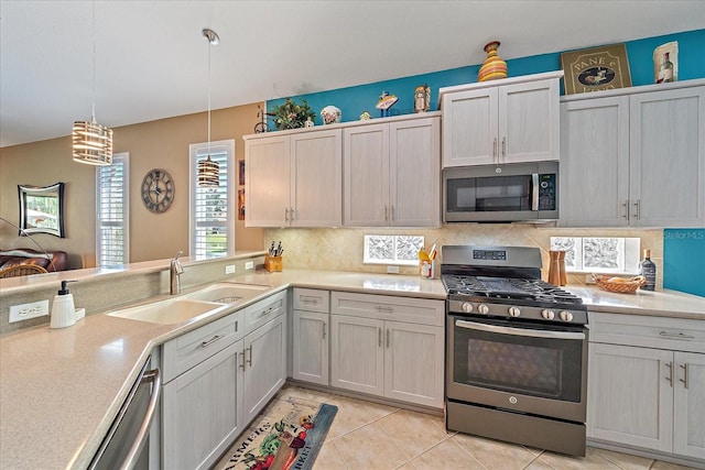 kitchen featuring stainless steel appliances, sink, light tile patterned flooring, backsplash, and pendant lighting