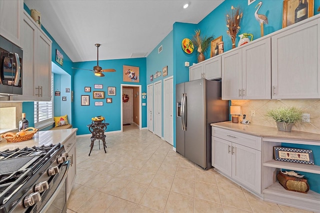 kitchen featuring white cabinets, appliances with stainless steel finishes, and vaulted ceiling