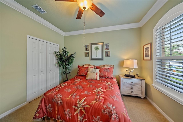 bedroom featuring ceiling fan, ornamental molding, a closet, and light colored carpet