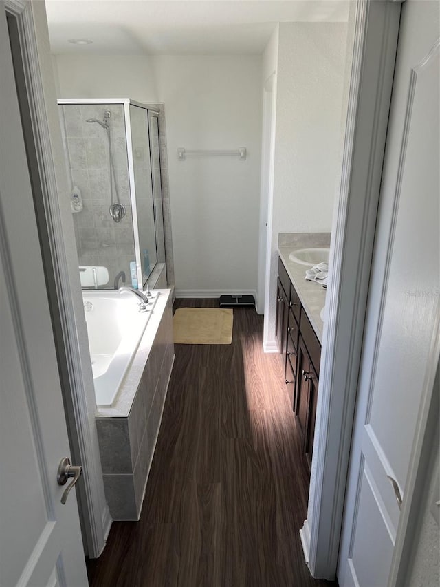 bathroom with hardwood / wood-style floors, vanity, and separate shower and tub