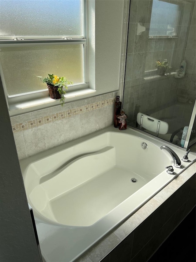 bathroom with a relaxing tiled tub