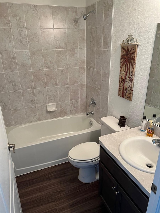 full bathroom with wood-type flooring, toilet, vanity, and tiled shower / bath