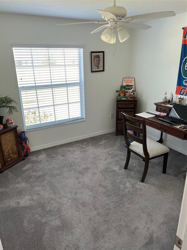 carpeted office space featuring ceiling fan and a healthy amount of sunlight