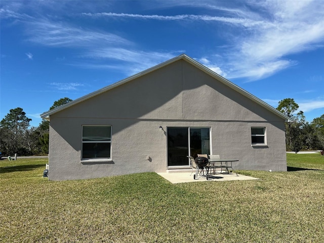 rear view of house featuring a lawn and a patio