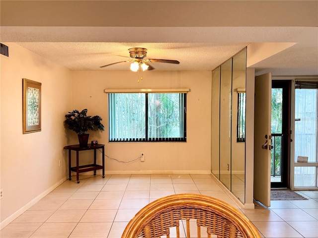 entrance foyer featuring light tile patterned floors, a textured ceiling, and a healthy amount of sunlight