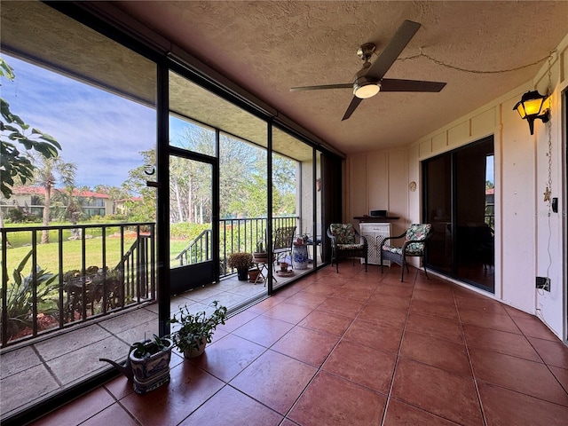 unfurnished sunroom with ceiling fan