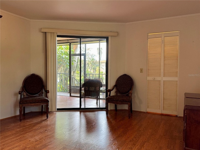 living area featuring hardwood / wood-style flooring and crown molding