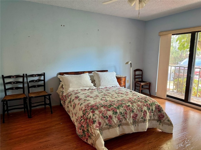 bedroom featuring access to outside, ceiling fan, wood-type flooring, and a textured ceiling