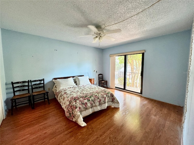 bedroom featuring access to exterior, wood-type flooring, a textured ceiling, and ceiling fan