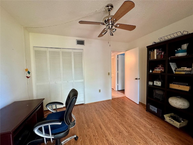 home office featuring ceiling fan, a textured ceiling, and hardwood / wood-style flooring