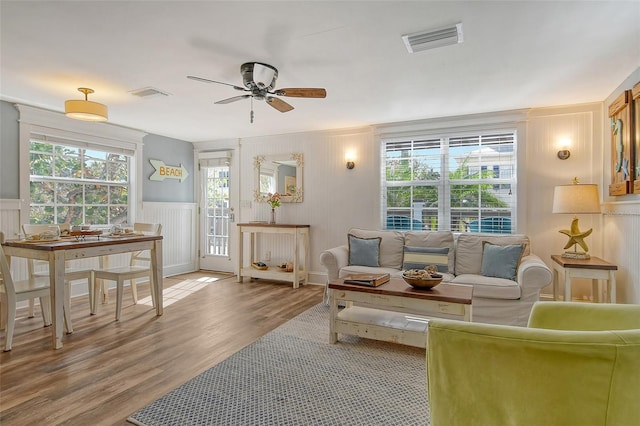 living room featuring ceiling fan, plenty of natural light, and light wood-type flooring