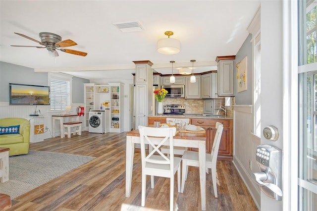 dining space featuring ceiling fan, dark hardwood / wood-style floors, and washer / clothes dryer