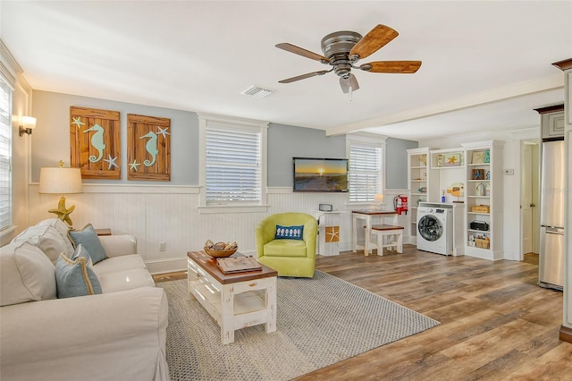 living room featuring ceiling fan, wood-type flooring, and washer / dryer