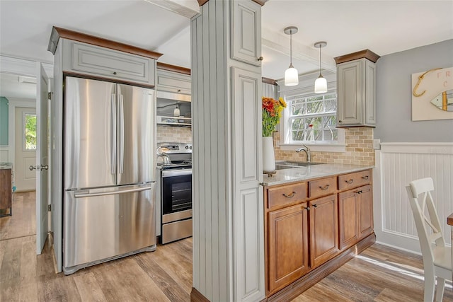 kitchen featuring light stone countertops, appliances with stainless steel finishes, a wealth of natural light, and light hardwood / wood-style flooring