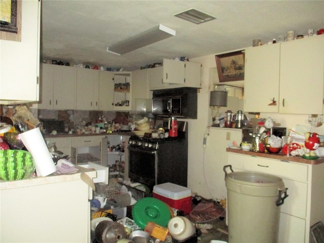 kitchen with visible vents, stainless steel microwave, and stove