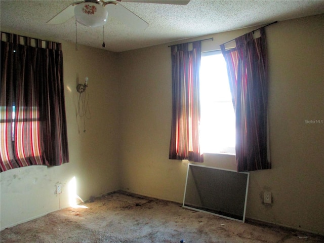 spare room featuring a textured ceiling and a ceiling fan