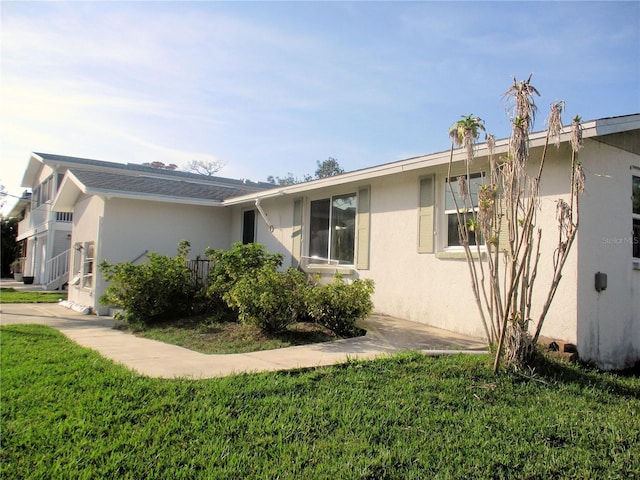 view of home's exterior with a lawn and stucco siding