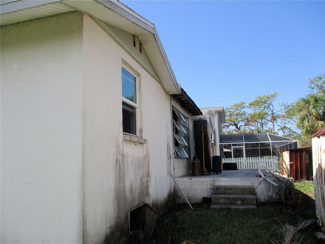 view of home's exterior featuring fence, a wooden deck, and stucco siding