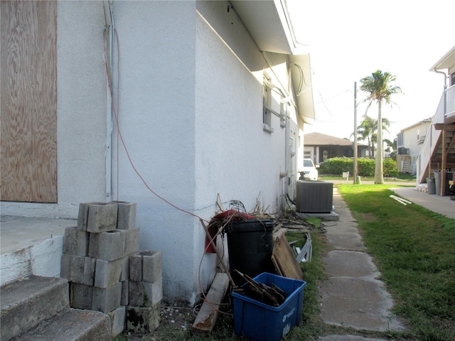 view of side of property with central air condition unit and stucco siding