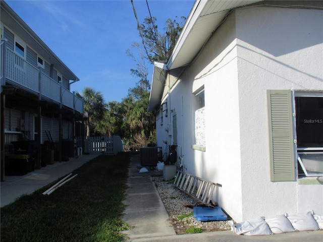 view of side of property featuring cooling unit and stucco siding