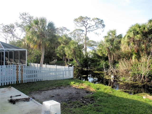 view of yard with a lanai and fence