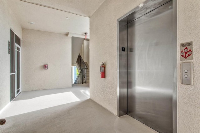 interior space featuring elevator and a textured ceiling