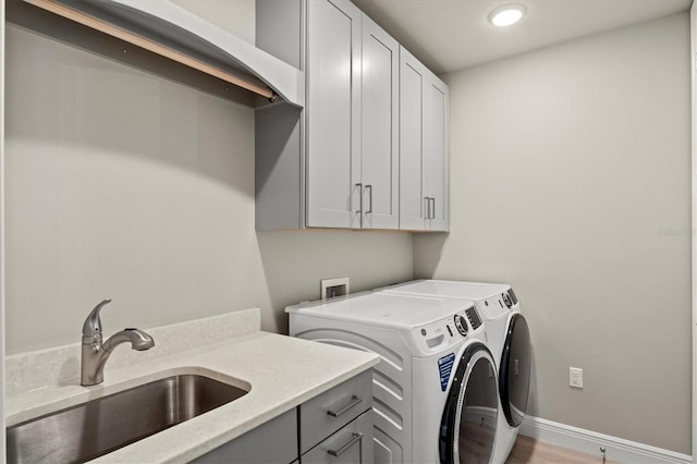 washroom featuring cabinets, wood-type flooring, sink, and independent washer and dryer