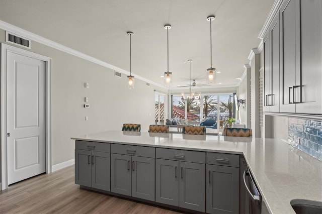 kitchen featuring gray cabinets, light hardwood / wood-style floors, and crown molding